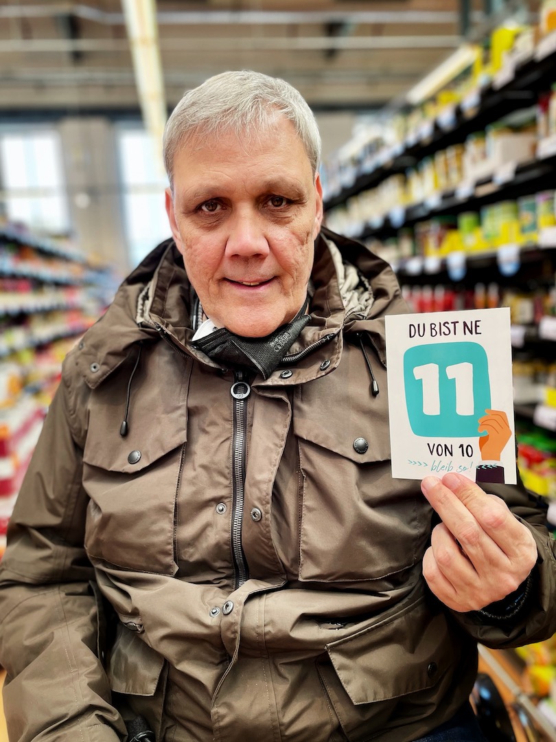 Frank mit einer Postkarte in der Hand